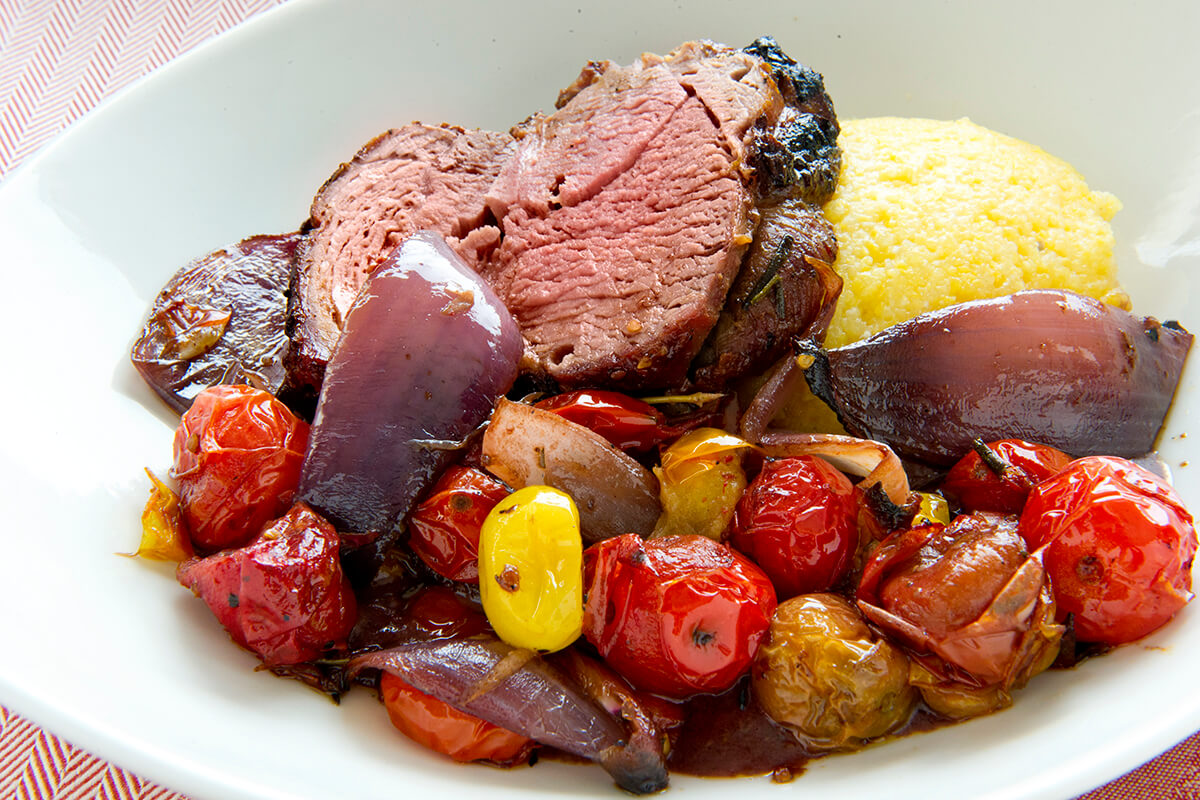 Spit-roasted Leg of Lamb over Grits and Tomatoes