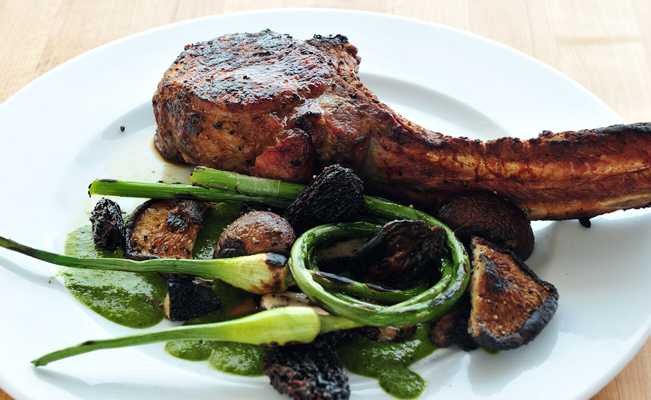 Image of Tomahawk Chops with Grilled Mushrooms and Garlic Scapes